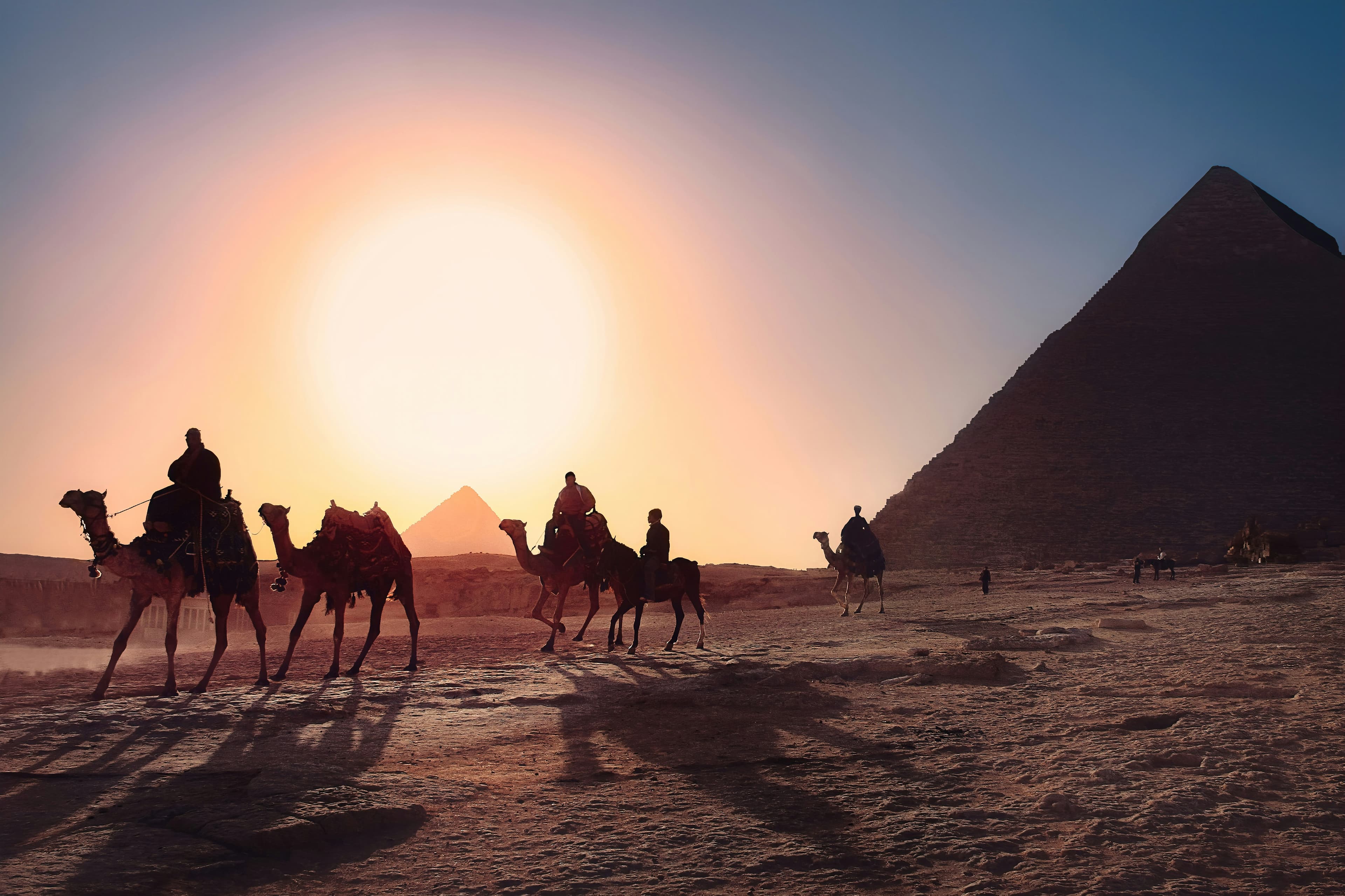 The Pyramids of Giza at sunset, seen across the Egyptian desert
